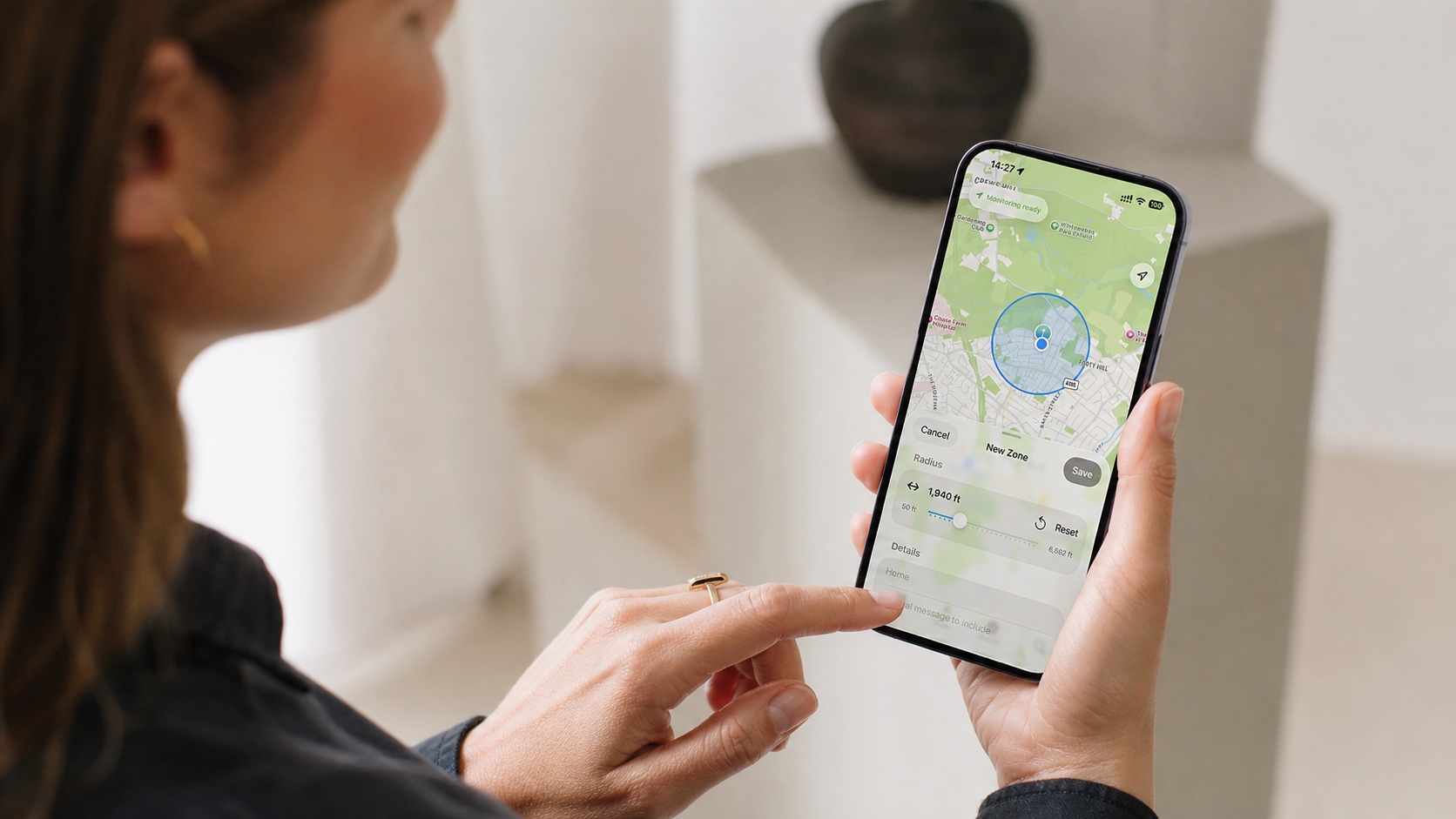 A woman using Ankom on her iPhone to set the radius of a new zone